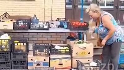 Une femme crache sur des légumes dans un supermarché