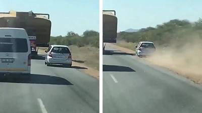 Un automobiliste tente de doubler un camion en passant par le bas-côté
