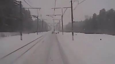 Des employés travaillent sur une ligne de chemin de fer quand un train arrive