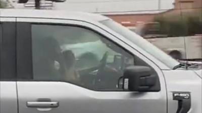 Une maman surprise en train de conduire avec son bébé sur les genoux pendant qu'elle téléphone